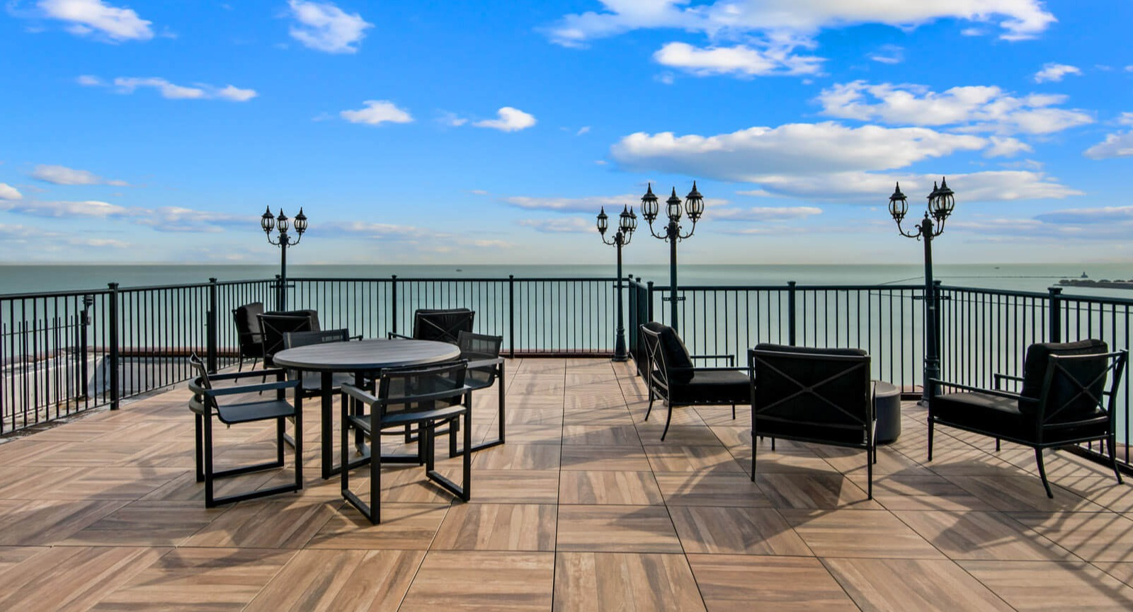 Elegant rooftop seating with contemporary furniture, charming lampposts, and stunning views of Lake Michigan at The Deco North Lake Shore in Chicago