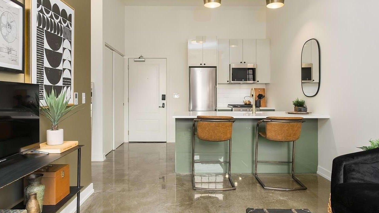 Thoughtfully designed studio apartment layout featuring a compact kitchen, bar seating, and a comfortable living area at The Duncan in Chicago
