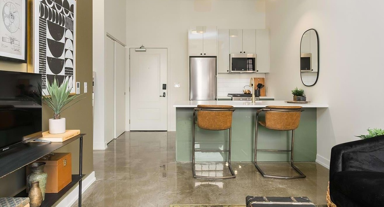 Thoughtfully designed studio apartment layout featuring a compact kitchen, bar seating, and a comfortable living area at The Duncan in Chicago