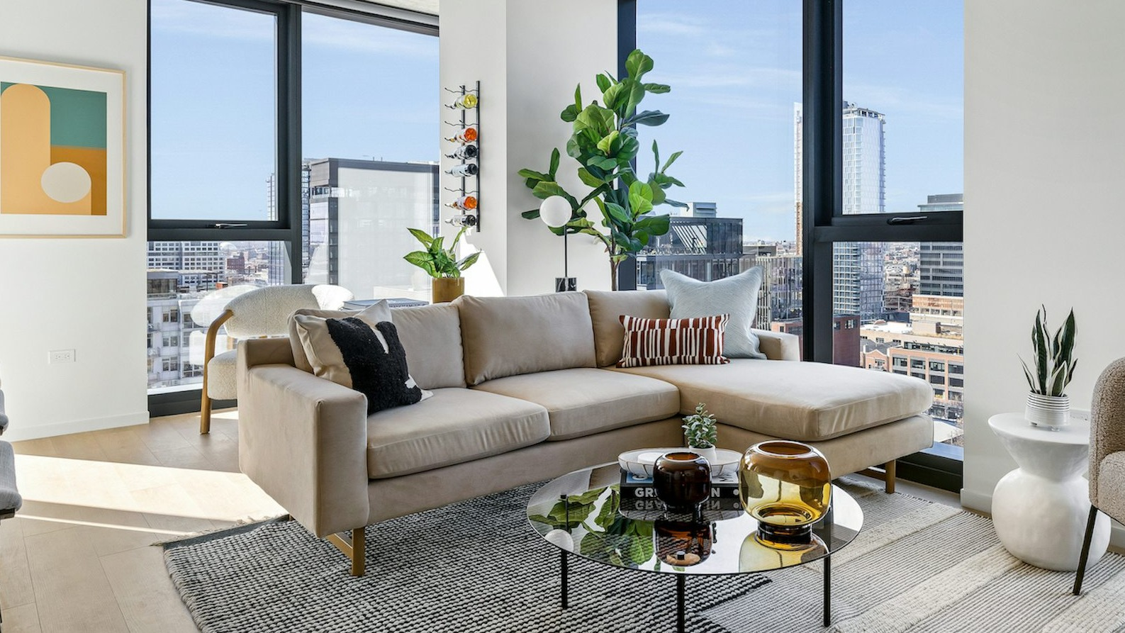 Chic living room featuring a stylish sectional sofa, unique coffee table, and large windows offering panoramic city views at The Dylan in Chicago