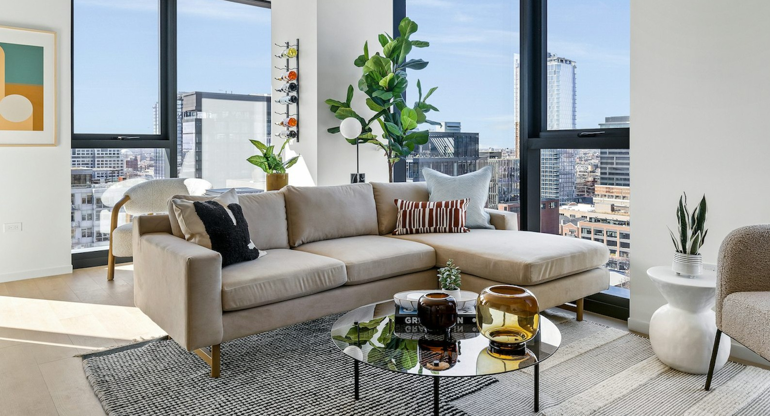 Chic living room featuring a stylish sectional sofa, unique coffee table, and large windows offering panoramic city views at The Dylan in Chicago