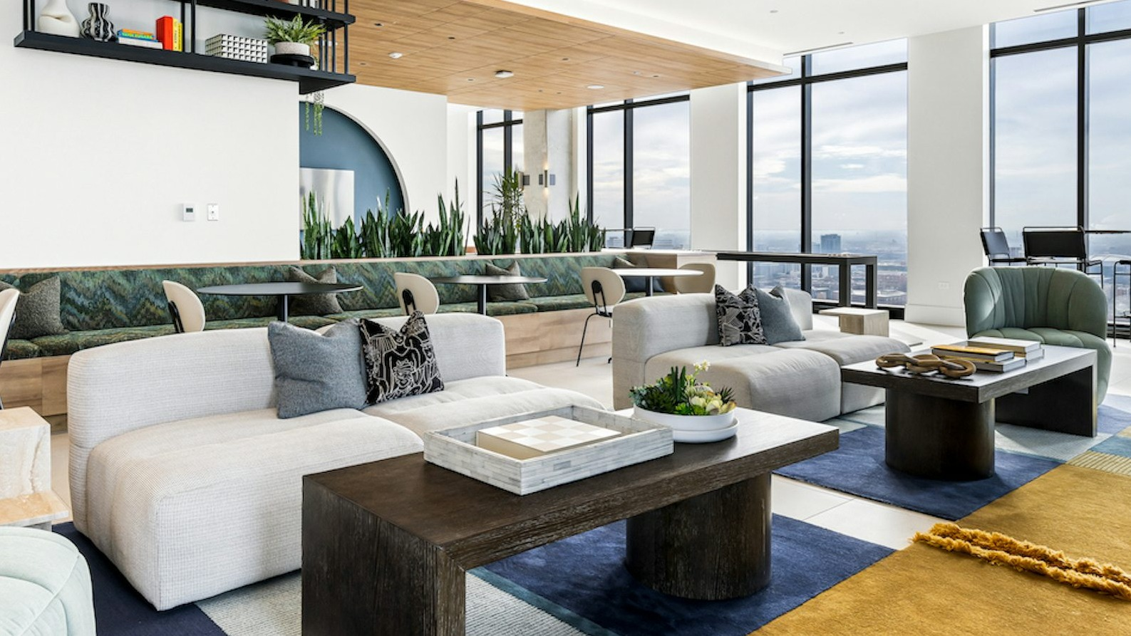 Elegant resident lounge area with diverse seating arrangements, stylish decor, and panoramic city views from large windows at The Dylan in Chicago