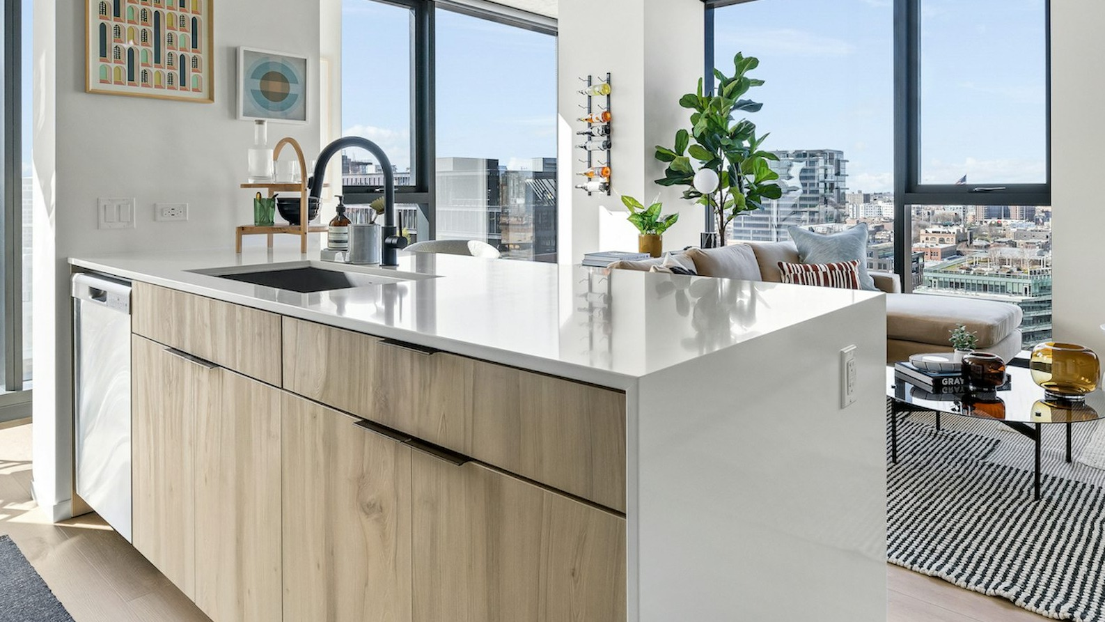 Bright luxury kitchen with a large island, seamless flow to a spacious living area, and expansive city views at The Dylan in Chicago