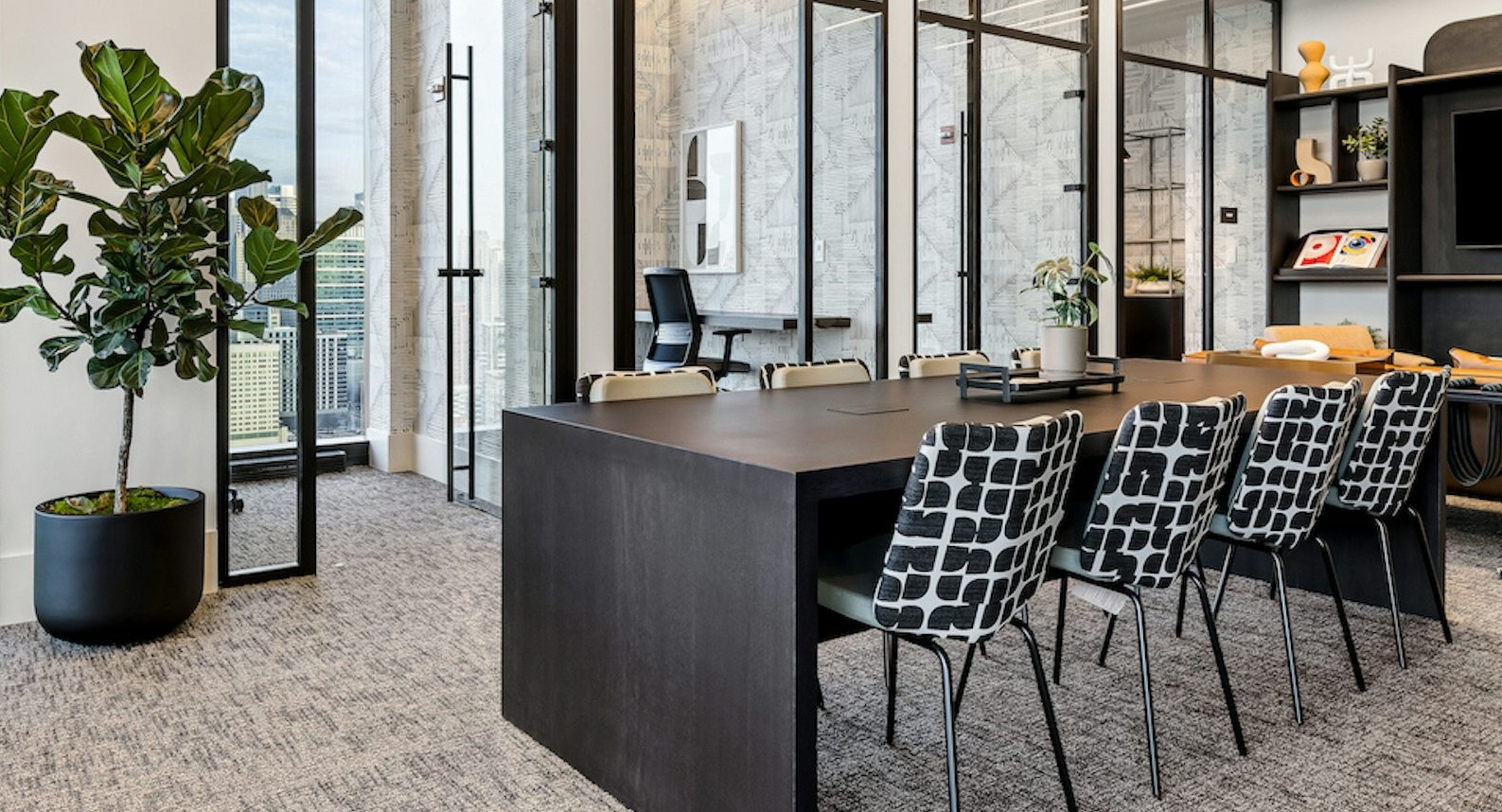 Modern co-working space at The Dylan in Chicago featuring a glass-enclosed conference room and contemporary seating