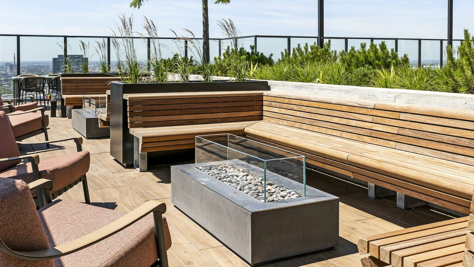 Beautiful outdoor pool area surrounded by sun loungers and trees, with a panoramic backdrop of the Chicago skyline at The Dylan