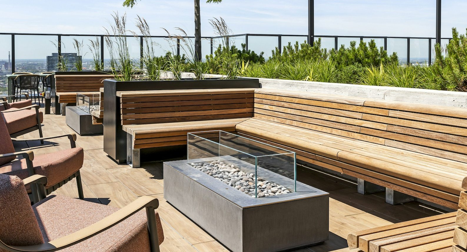 Beautiful outdoor pool area surrounded by sun loungers and trees, with a panoramic backdrop of the Chicago skyline at The Dylan