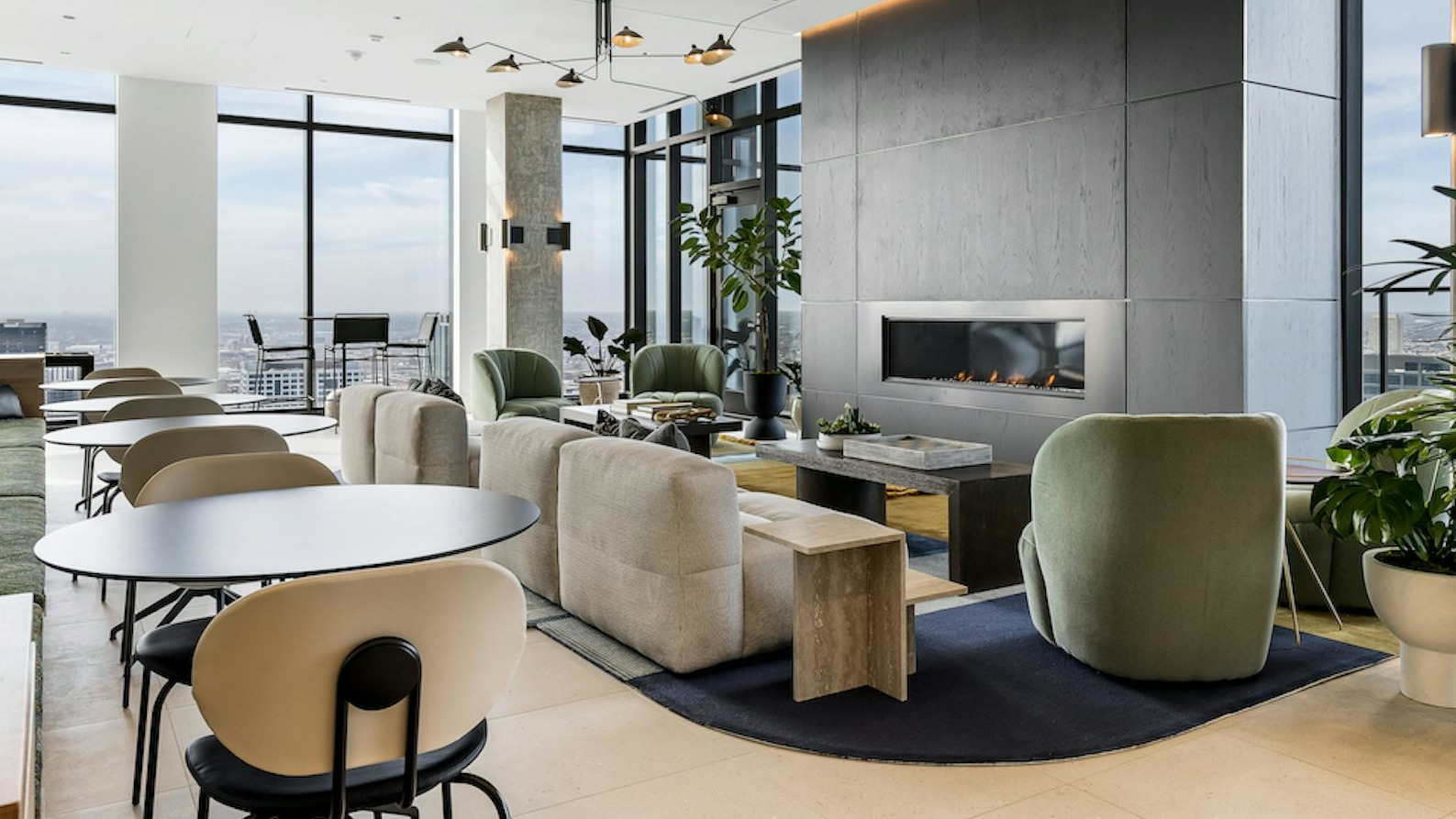 Sophisticated resident lounge with comfortable seating, a modern fireplace, and expansive city views from large windows at The Dylan in Chicago