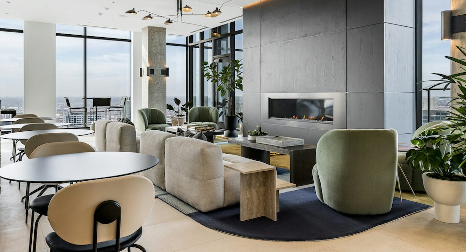 Sophisticated resident lounge with comfortable seating, a modern fireplace, and expansive city views from large windows at The Dylan in Chicago