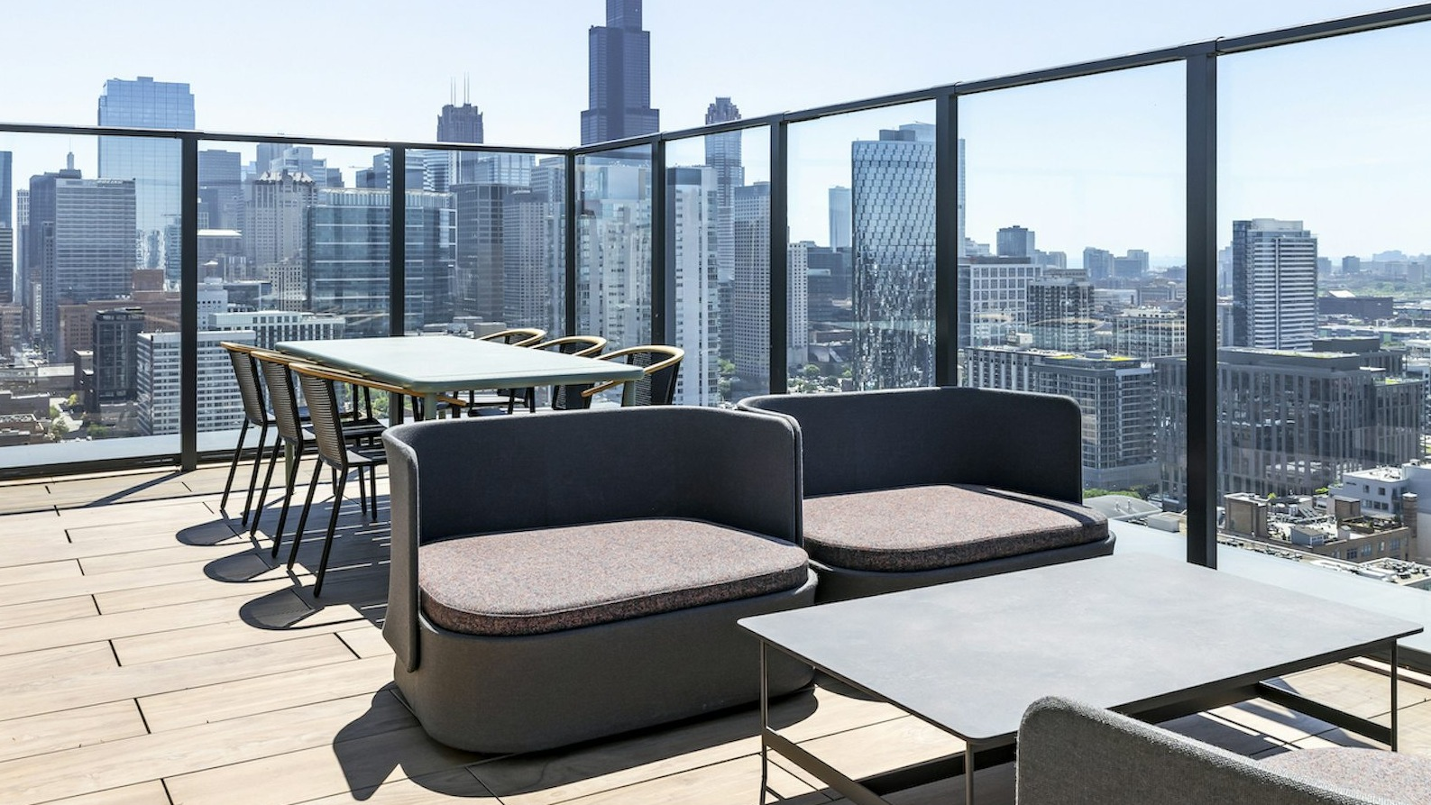 Expansive rooftop lounge area with modern outdoor seating, dining tables, and spectacular panoramic views of the Chicago skyline at The Dylan