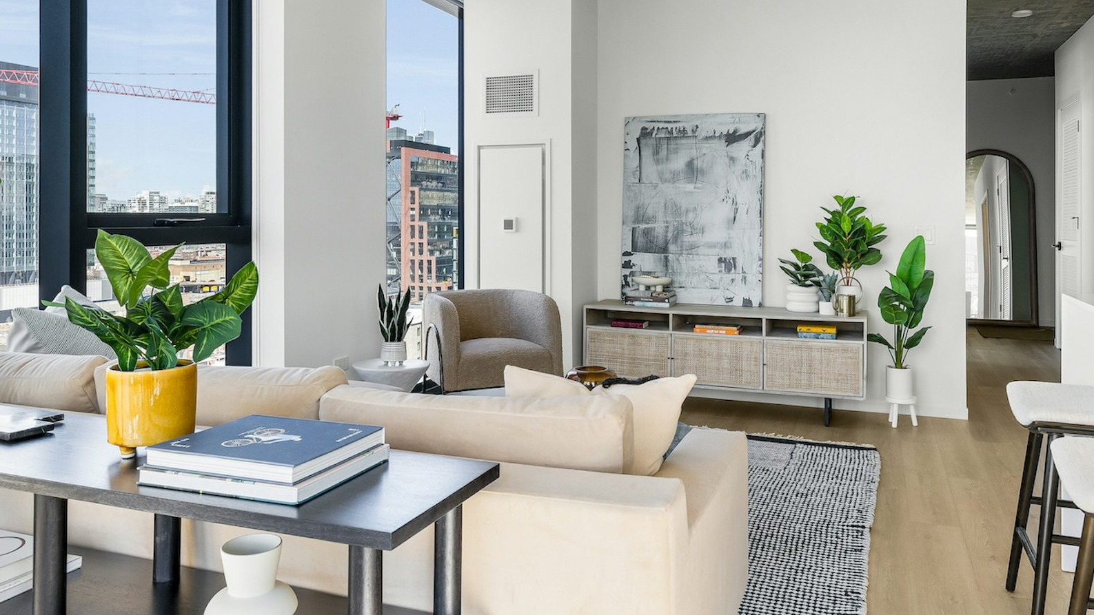 Bright and spacious living room with an elegant sofa, modern decor, and large windows providing panoramic city views at The Dylan in Chicago