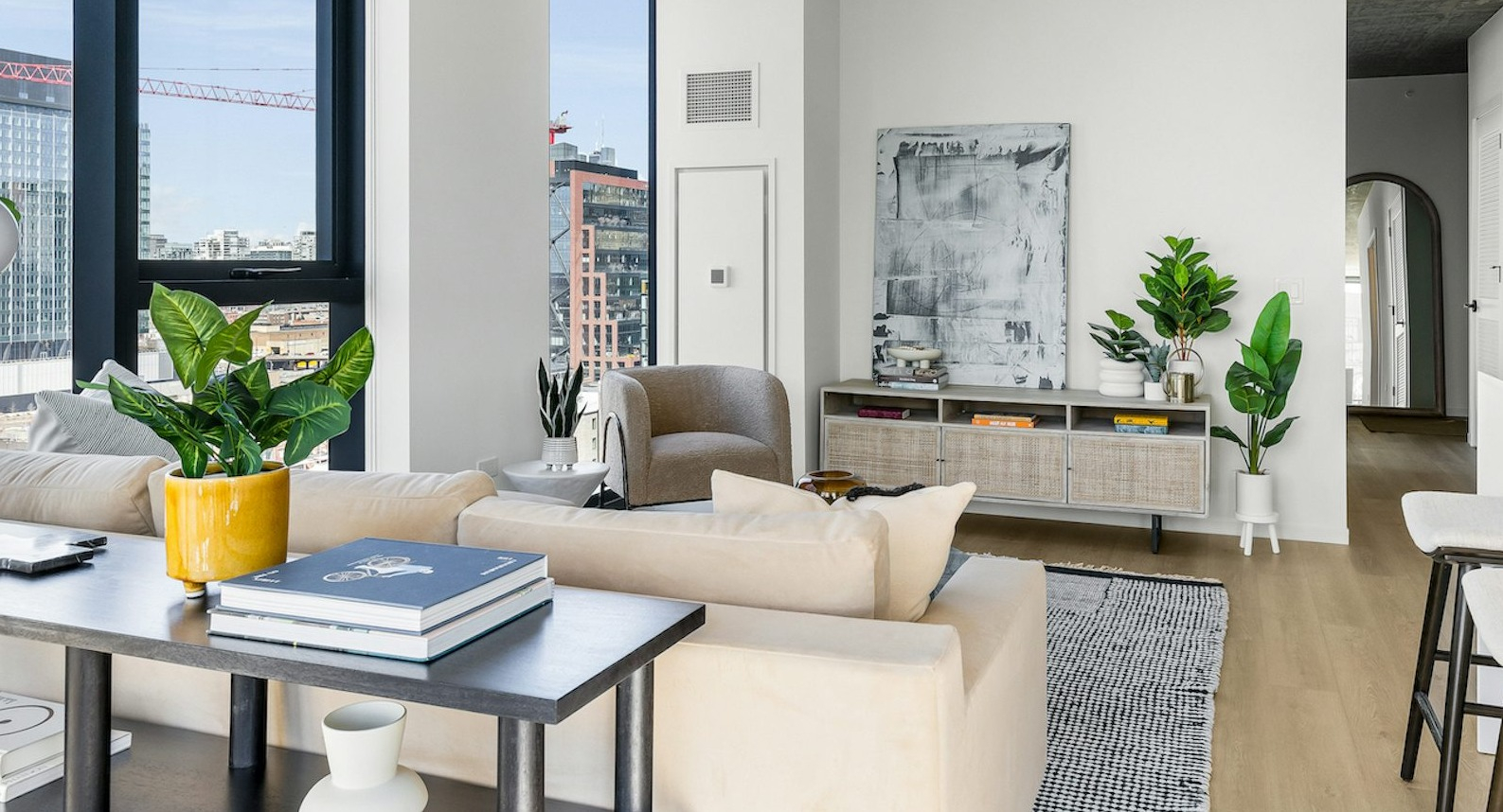 Bright and spacious living room with an elegant sofa, modern decor, and large windows providing panoramic city views at The Dylan in Chicago