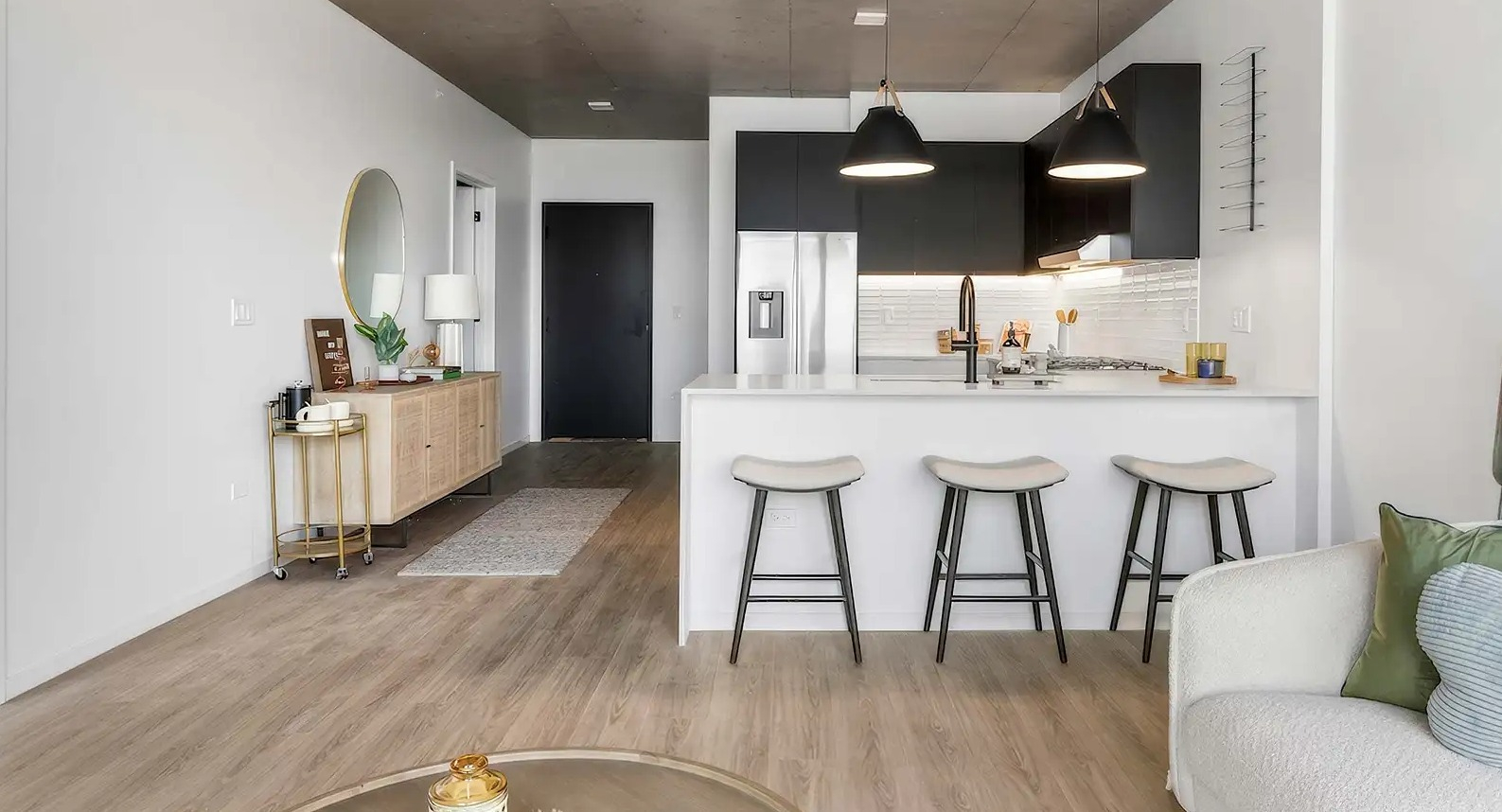 Welcoming apartment entryway leading into a spacious living room and modern kitchen at The Elizabeth Chicago