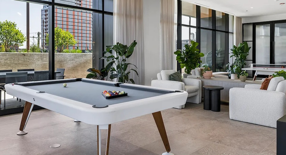 Stylish game room at The Elizabeth Chicago, featuring a modern billiards table and comfortable lounge seating