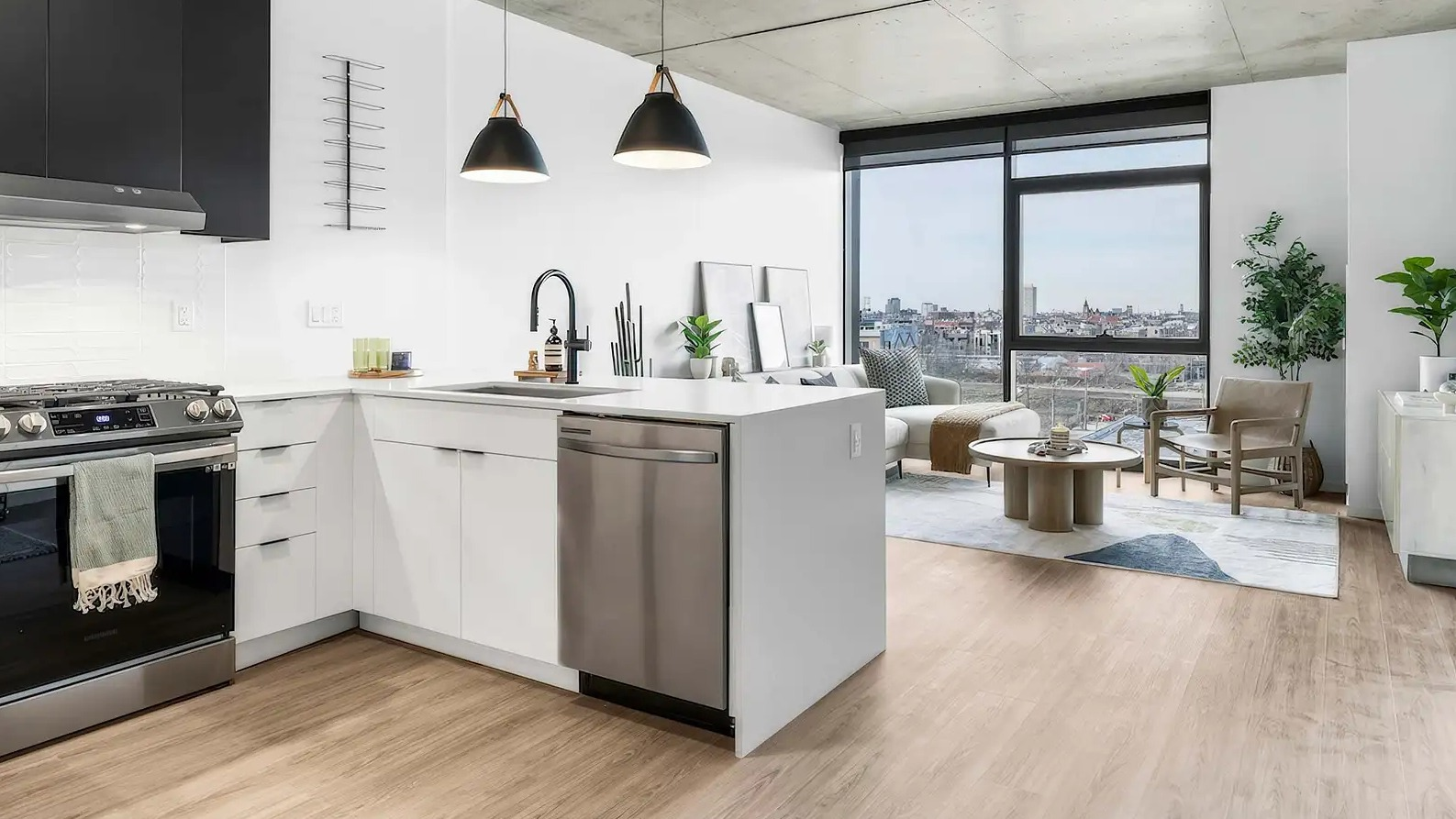 Open-plan kitchen and living area at The Elizabeth Chicago, featuring a modern kitchen with black and white cabinets and a bright living space