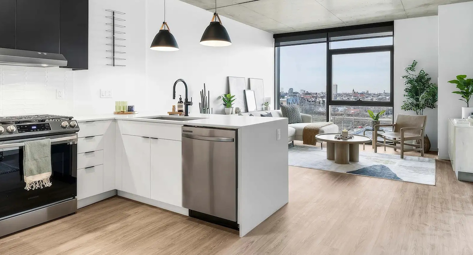 Open-plan kitchen and living area at The Elizabeth Chicago, featuring a modern kitchen with black and white cabinets and a bright living space