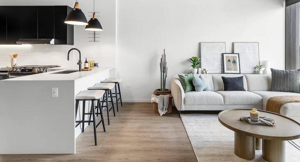 Open-concept kitchen and living area at The Elizabeth Chicago, featuring a white island, dark cabinetry, and a comfortable sofa