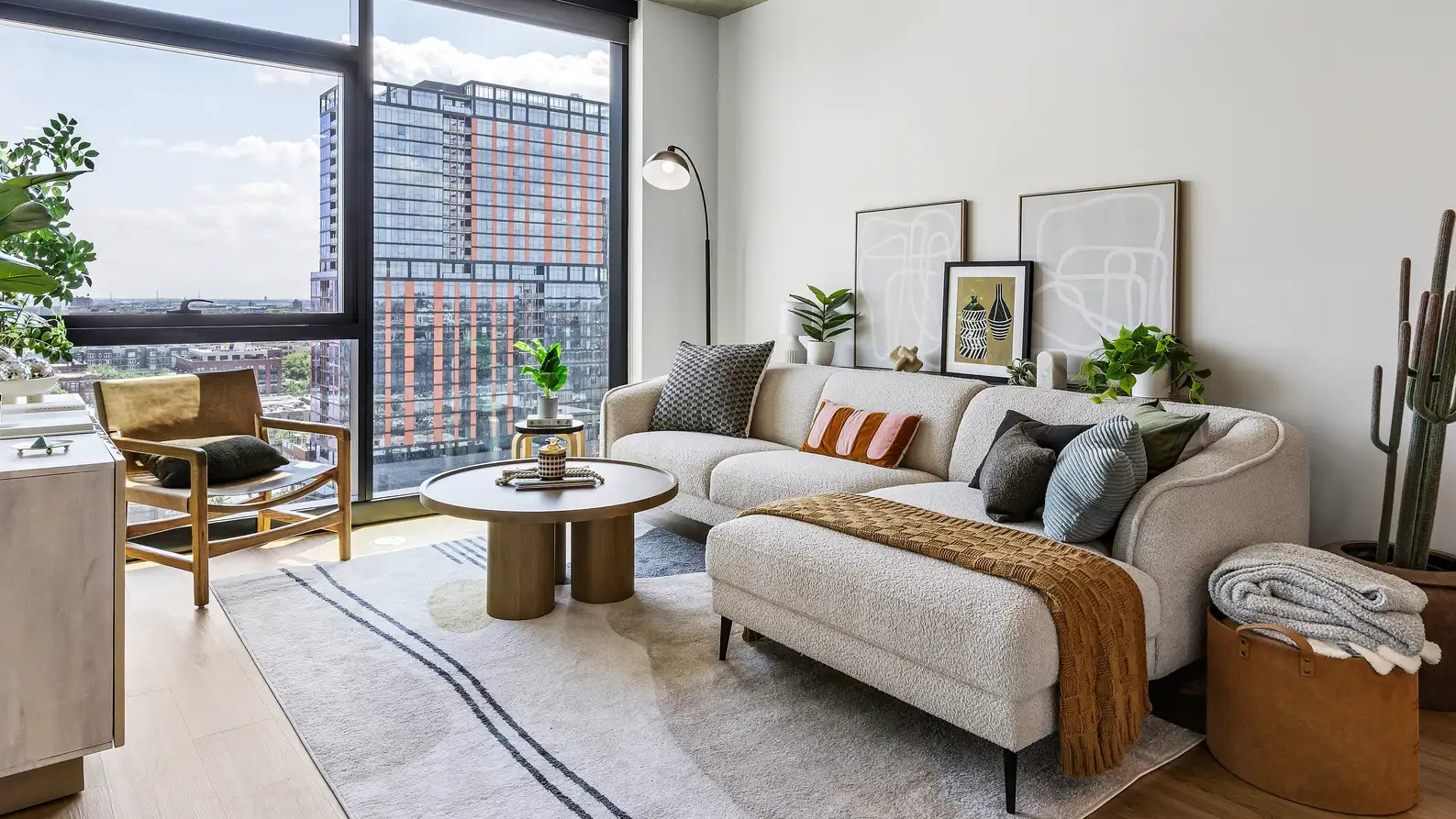 Bright living room at The Elizabeth Chicago, featuring a cozy sofa, stylish decor, and access to a private balcony with city views