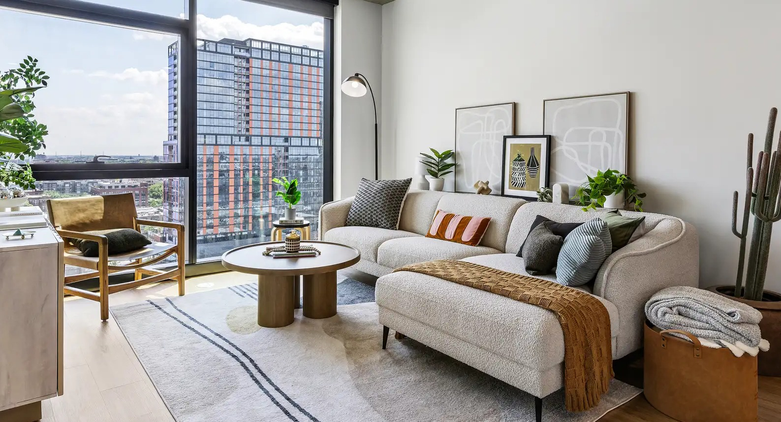 Bright living room at The Elizabeth Chicago, featuring a cozy sofa, stylish decor, and access to a private balcony with city views
