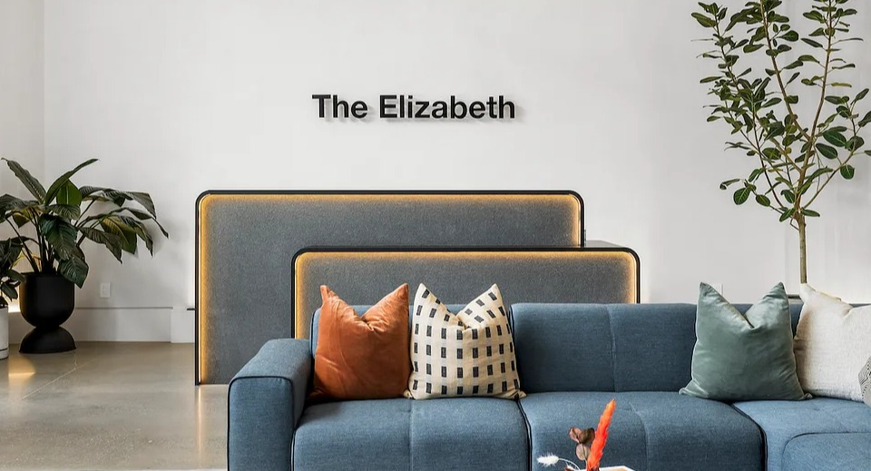 Welcoming lobby entrance at The Elizabeth Chicago, featuring a comfortable blue sofa, modern lighting, and elegant decor