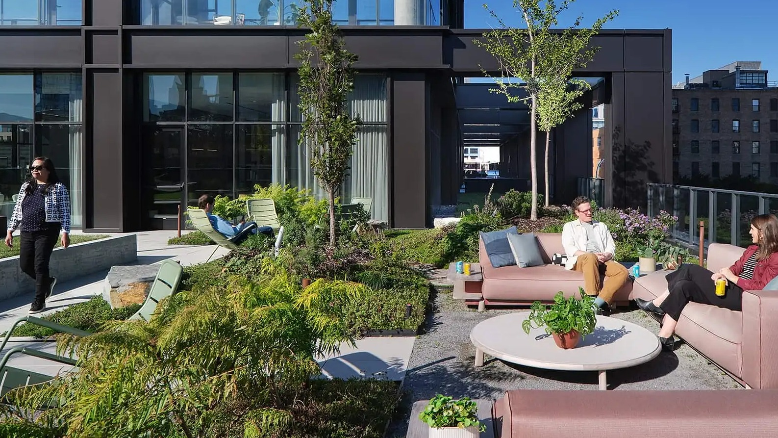 Spacious outdoor lounge area at The Elizabeth Chicago, featuring comfortable sofas, stylish chairs, and a beautifully landscaped garden