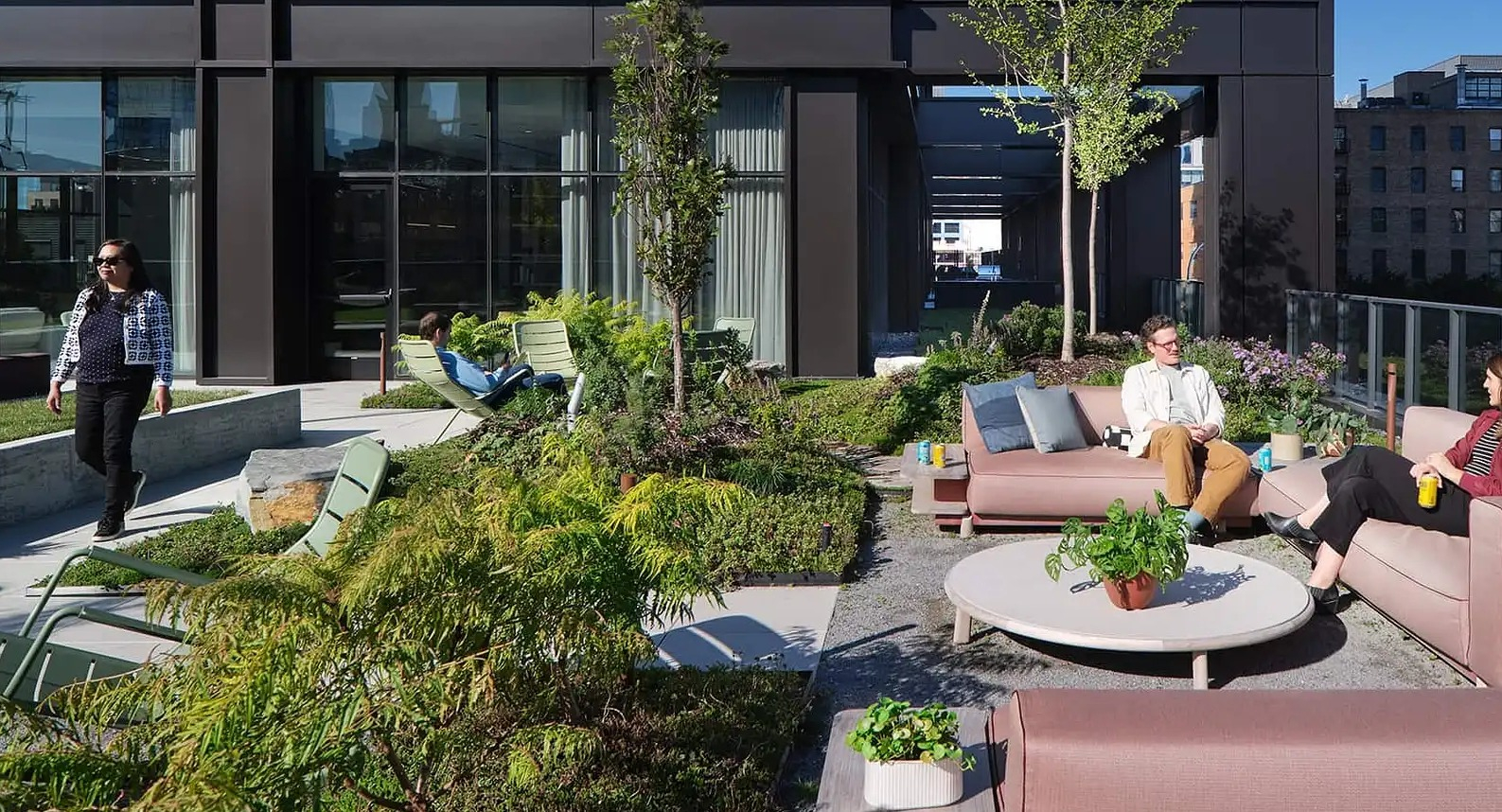 Spacious outdoor lounge area at The Elizabeth Chicago, featuring comfortable sofas, stylish chairs, and a beautifully landscaped garden