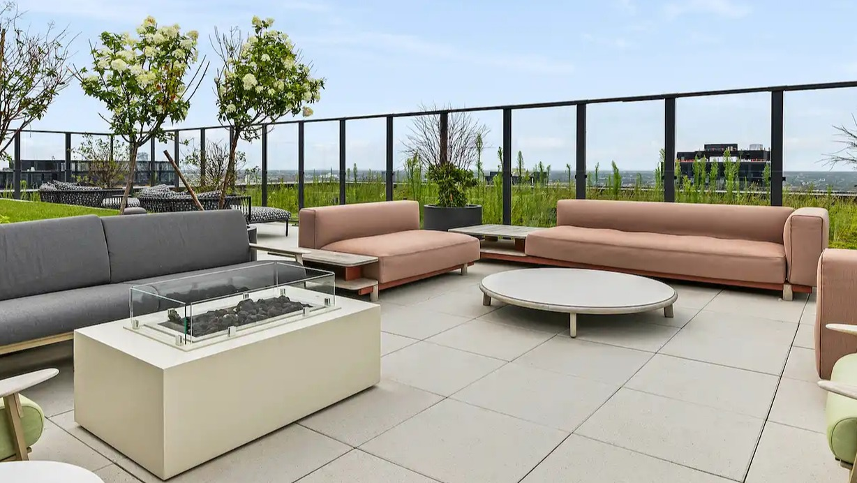 Luxurious outdoor lounge at The Elizabeth Chicago, featuring comfortable sofas, accent chairs, and a modern fire pit