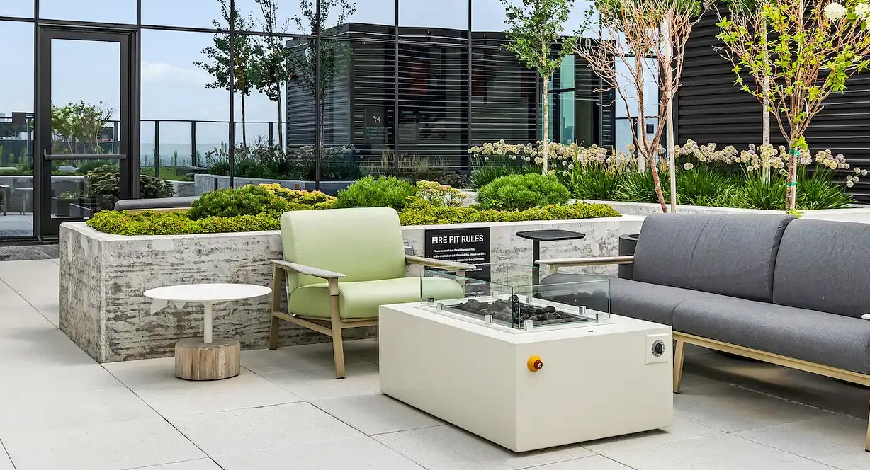 Beautiful outdoor lounge area at The Elizabeth Chicago, featuring comfortable seating, a modern fire pit, and landscaped greenery