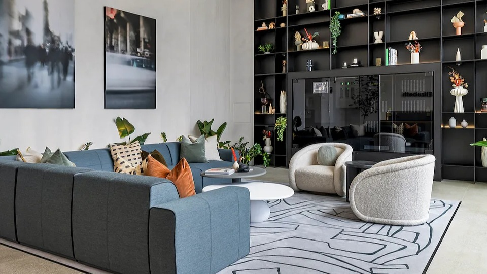 Grand resident lounge at The Elizabeth Chicago, featuring a large sectional sofa, artistic shelving, and contemporary decor