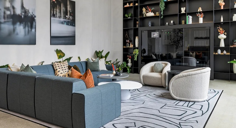 Grand resident lounge at The Elizabeth Chicago, featuring a large sectional sofa, artistic shelving, and contemporary decor