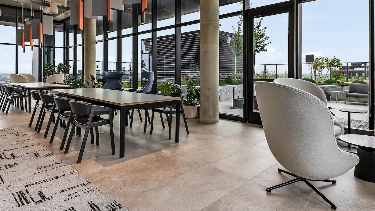 Spacious resident lounge at The Elizabeth Chicago, featuring diverse seating arrangements, large windows, and a dedicated workspace