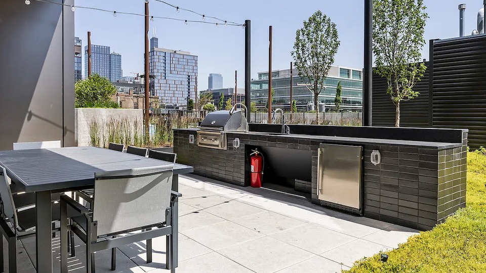 Expansive rooftop grilling area at The Elizabeth Chicago, featuring modern BBQ stations and outdoor dining tables