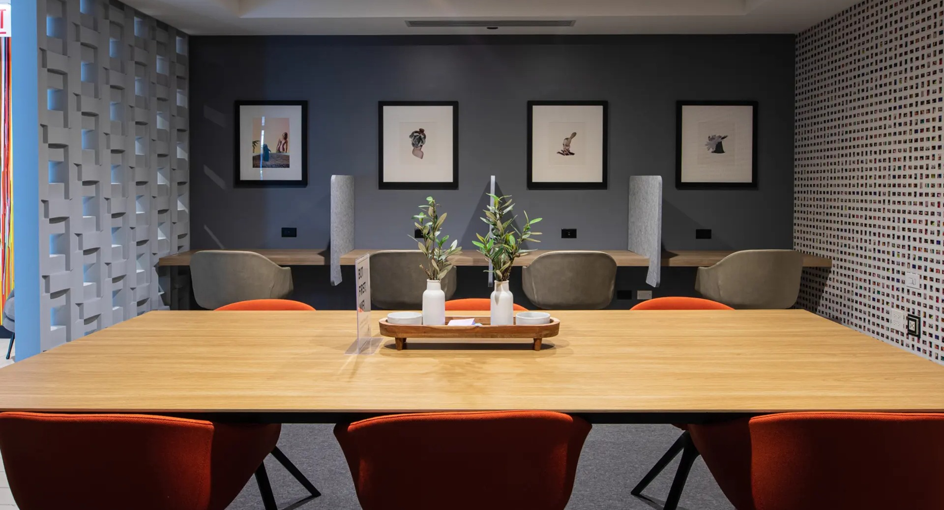 Modern business lounge featuring a large communal table, private work pods, and vibrant artwork at The Gallery on Wells in Chicago