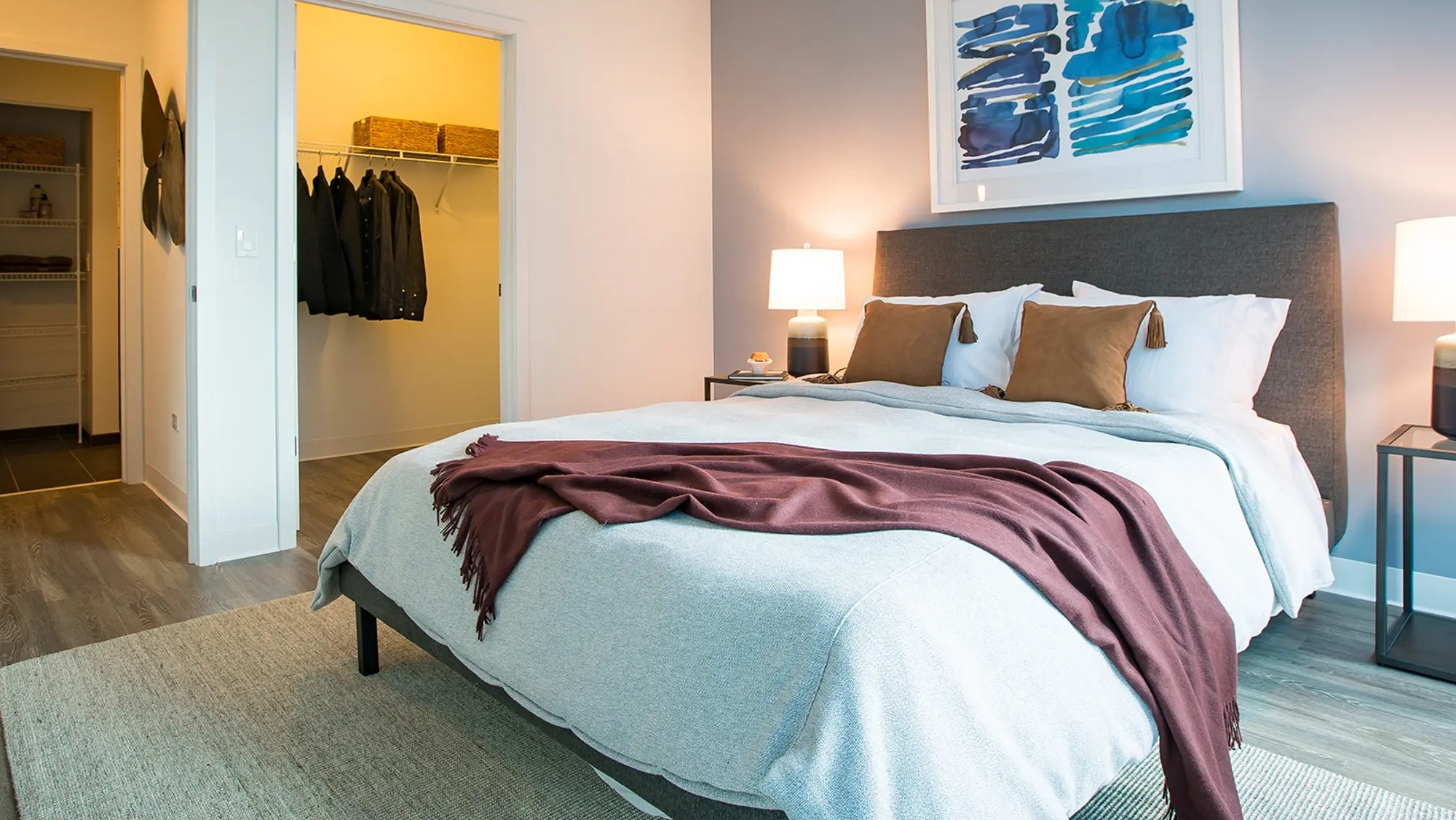 Inviting bedroom with a comfortable bed, vibrant accent wall, and a convenient walk-in closet at The Gallery on Wells in Chicago