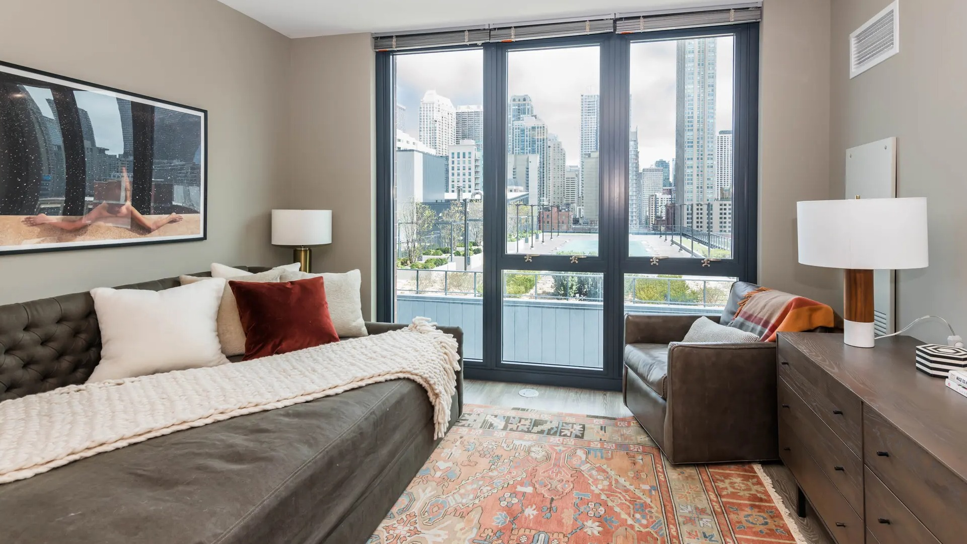 Cozy living room with a comfortable sofa, elegant decor, and a private balcony access with city views at The Gallery on Wells in Chicago