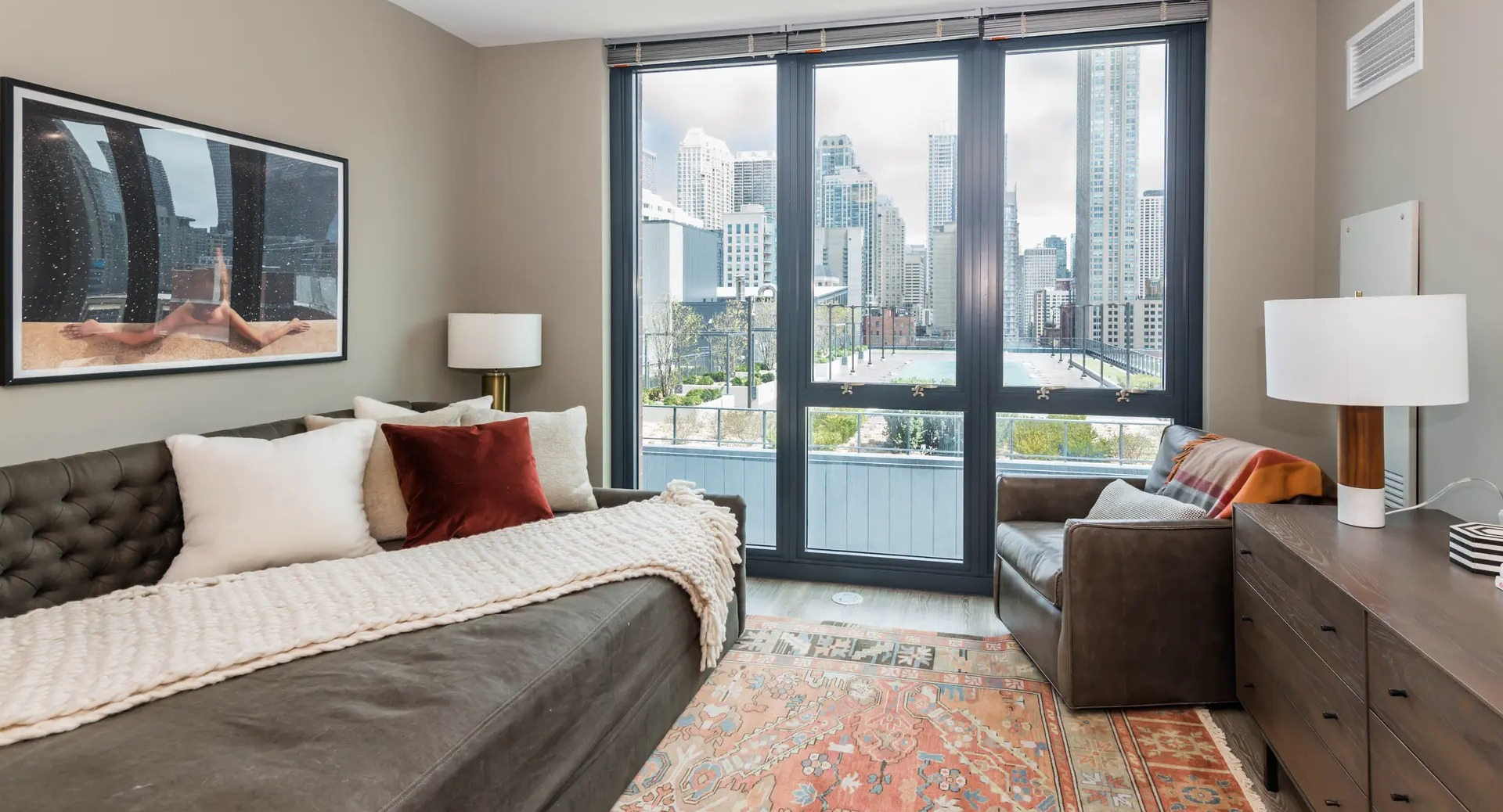 Cozy living room with a comfortable sofa, elegant decor, and a private balcony access with city views at The Gallery on Wells in Chicago