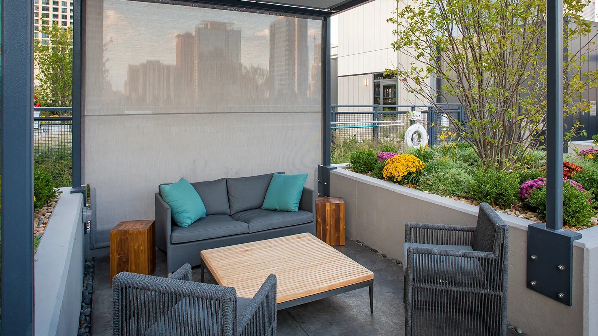 Cozy outdoor cabana lounge with a comfortable sofa, armchairs, and lush planters, offering a private retreat at The Gallery on Wells in Chicago