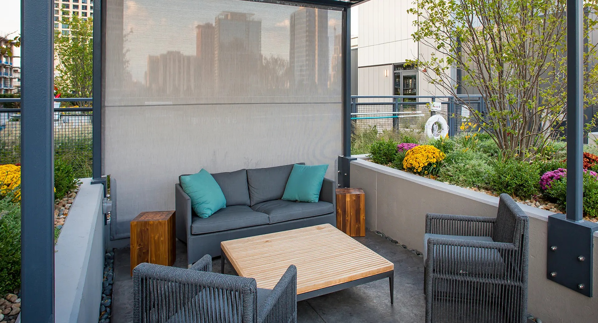 Cozy outdoor cabana lounge with a comfortable sofa, armchairs, and lush planters, offering a private retreat at The Gallery on Wells in Chicago