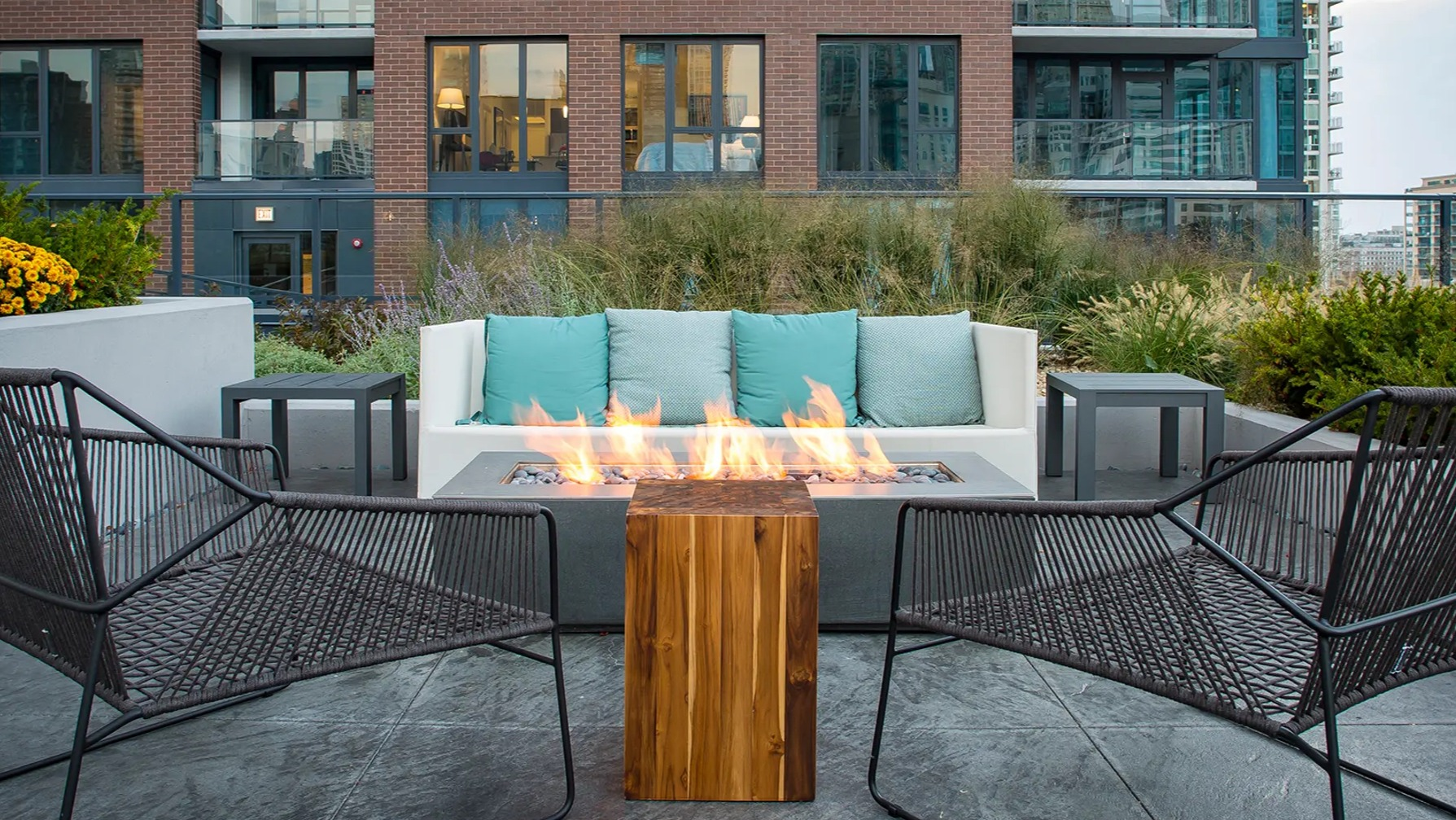 Inviting outdoor lounge area with a cozy fire pit, comfortable seating, and modern urban landscaping at The Gallery on Wells in Chicago