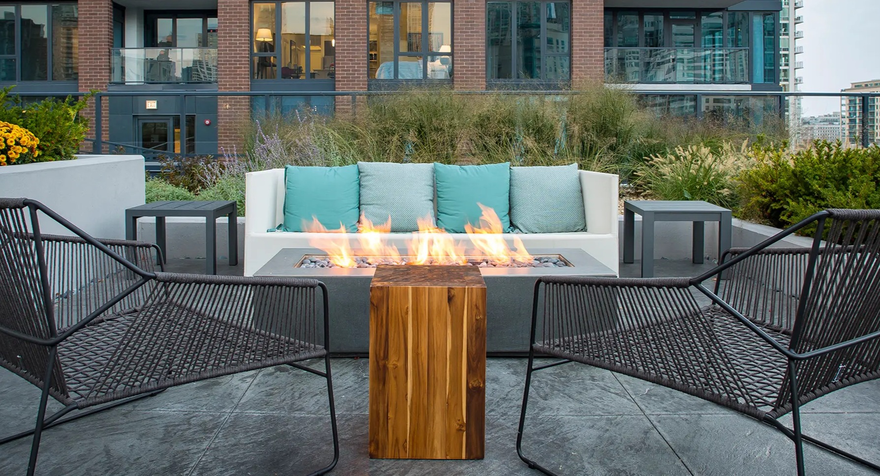 Inviting outdoor lounge area with a cozy fire pit, comfortable seating, and modern urban landscaping at The Gallery on Wells in Chicago