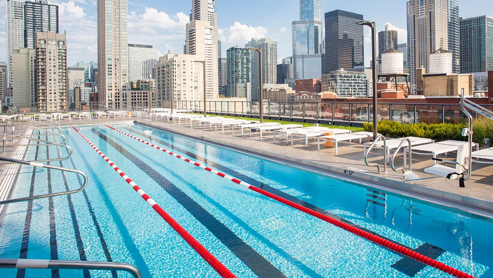 Impressive outdoor lap pool with lounge chairs and breathtaking views of the Chicago skyline at The Gallery on Wells apartments