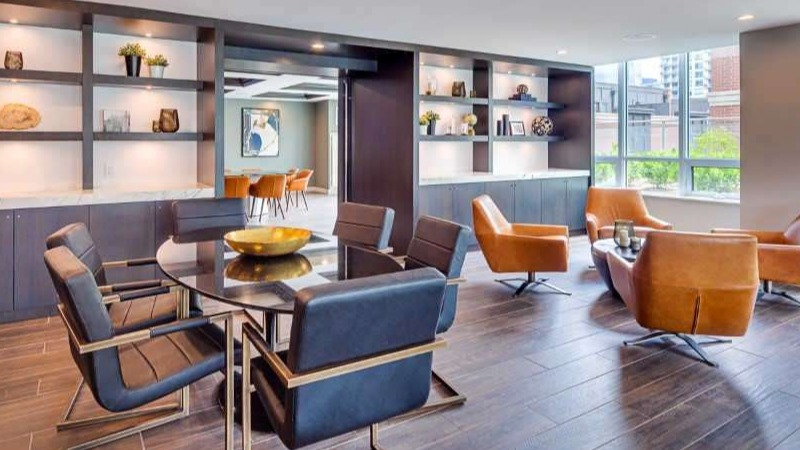Elegant clubroom at The Hudson in Chicago, featuring diverse seating arrangements, communal tables, and stylish shelving