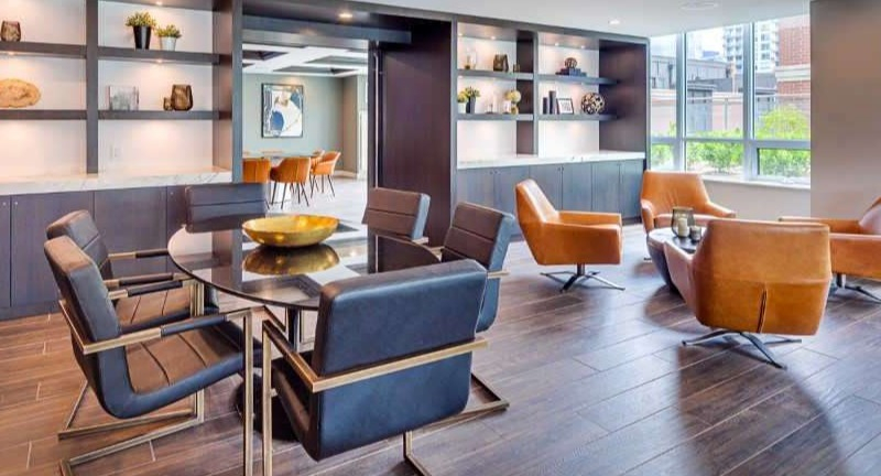 Elegant clubroom at The Hudson in Chicago, featuring diverse seating arrangements, communal tables, and stylish shelving