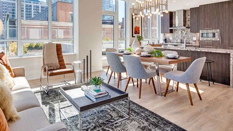 Bright and modern living room and dining area at The Hudson in Chicago, featuring comfortable seating, a stylish dining set, and city views