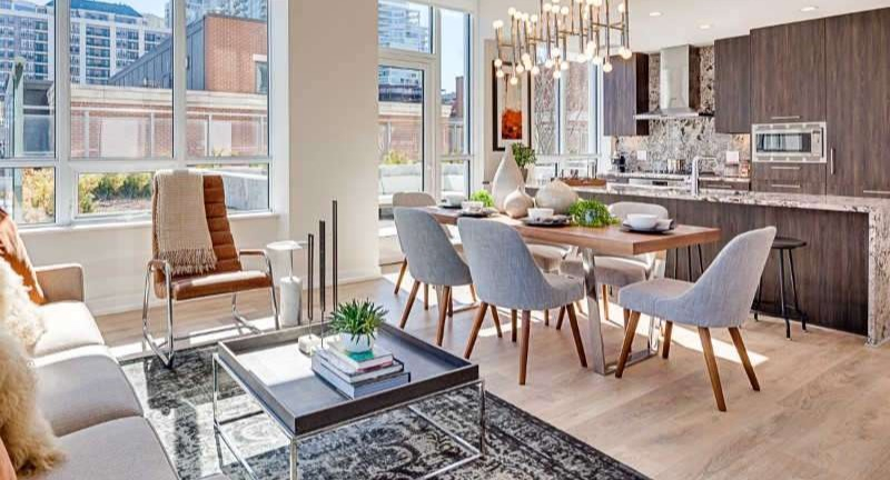 Bright and modern living room and dining area at The Hudson in Chicago, featuring comfortable seating, a stylish dining set, and city views
