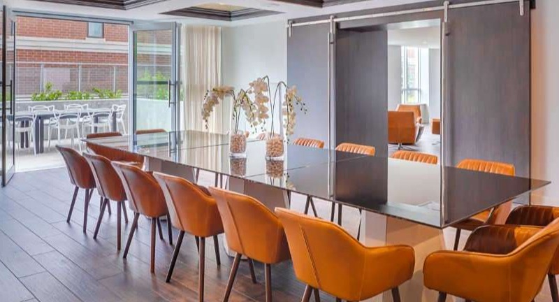 Elegant private dining room at The Hudson in Chicago, featuring a large table with seating and access to an outdoor patio