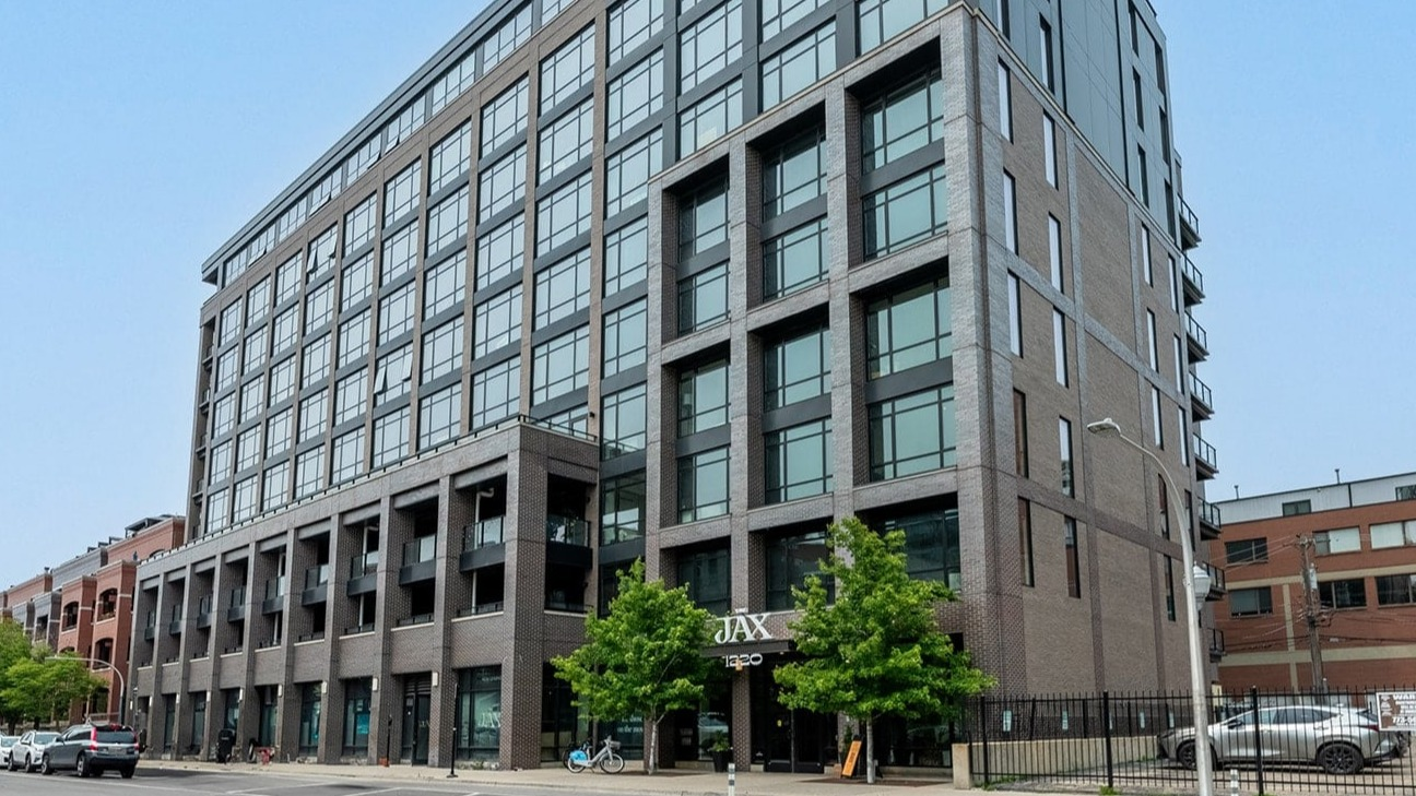 Modern apartment building exterior of The Jax in Chicago, featuring sleek architecture and contemporary design