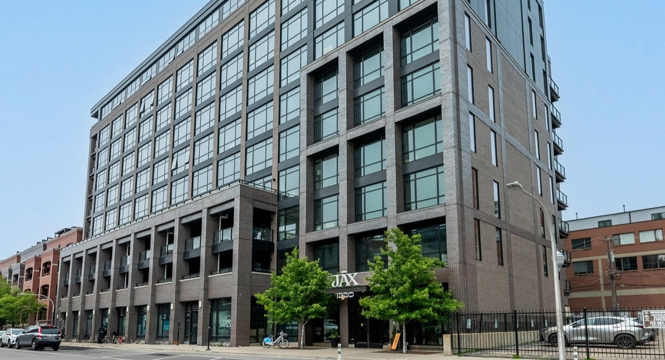 Modern apartment building exterior of The Jax in Chicago, featuring sleek architecture and contemporary design
