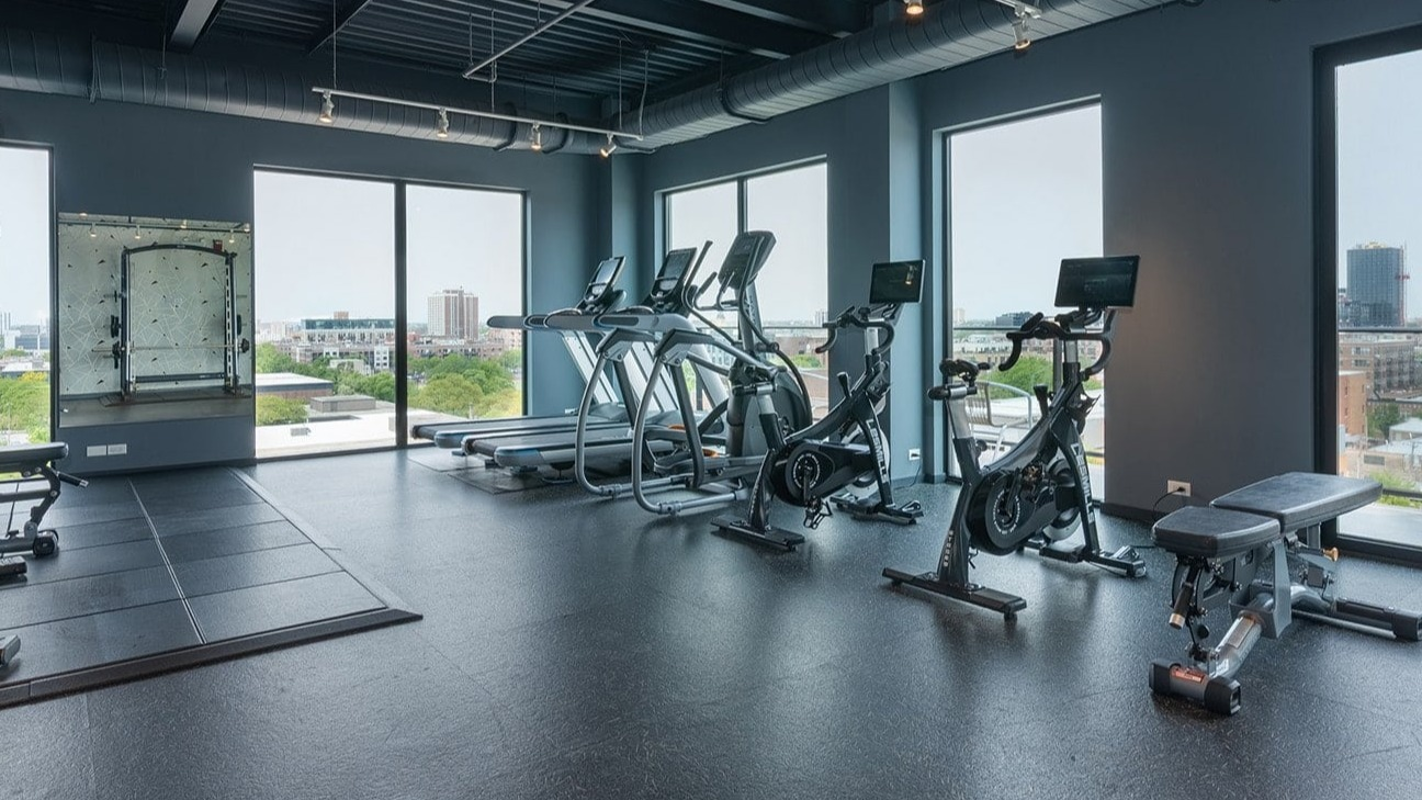 State-of-the-art fitness center at The Jax in Chicago, featuring various weight machines, benches, and city views