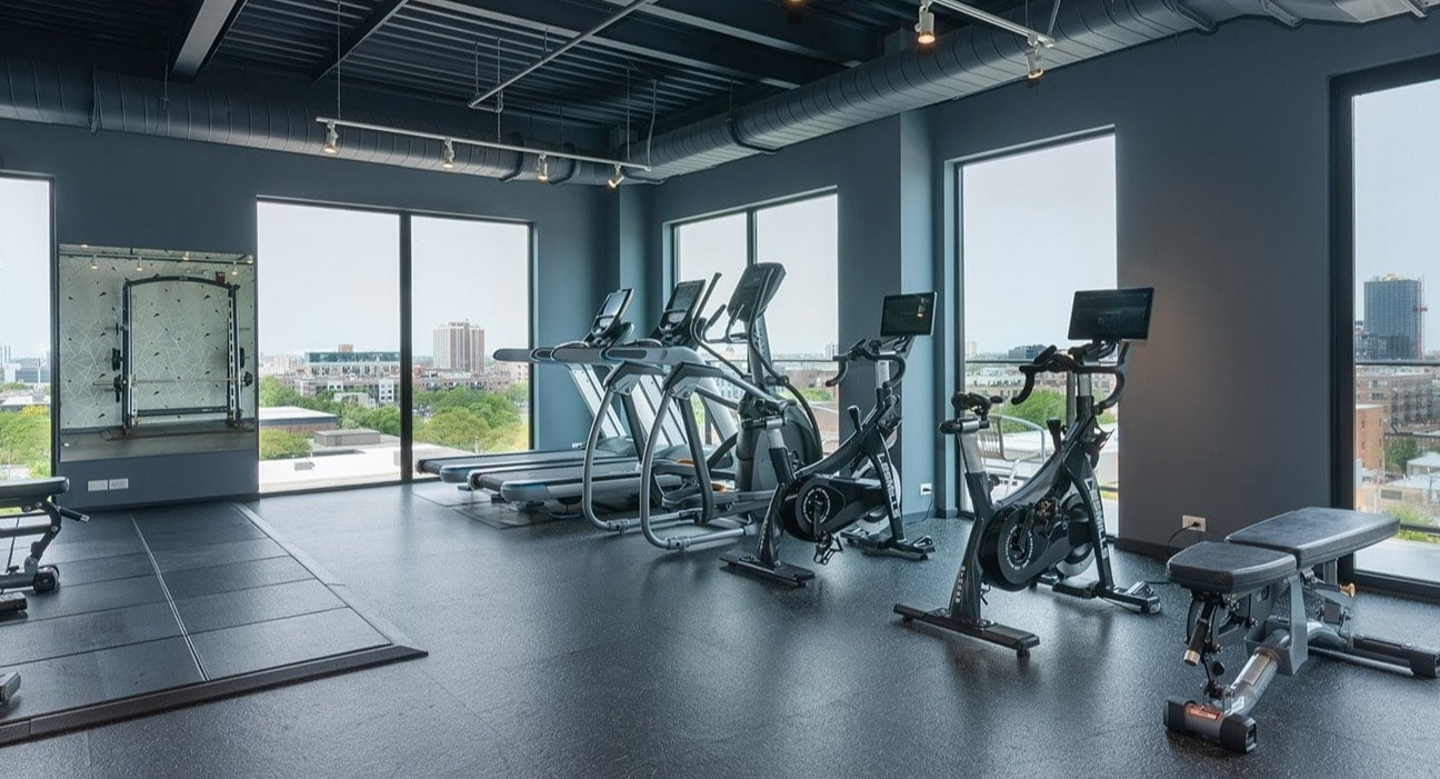 State-of-the-art fitness center at The Jax in Chicago, featuring various weight machines, benches, and city views