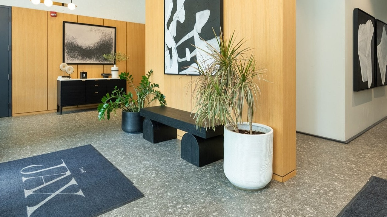 Stylish lobby entrance at The Jax in Chicago, featuring modern art, warm wood accents, and inviting decor